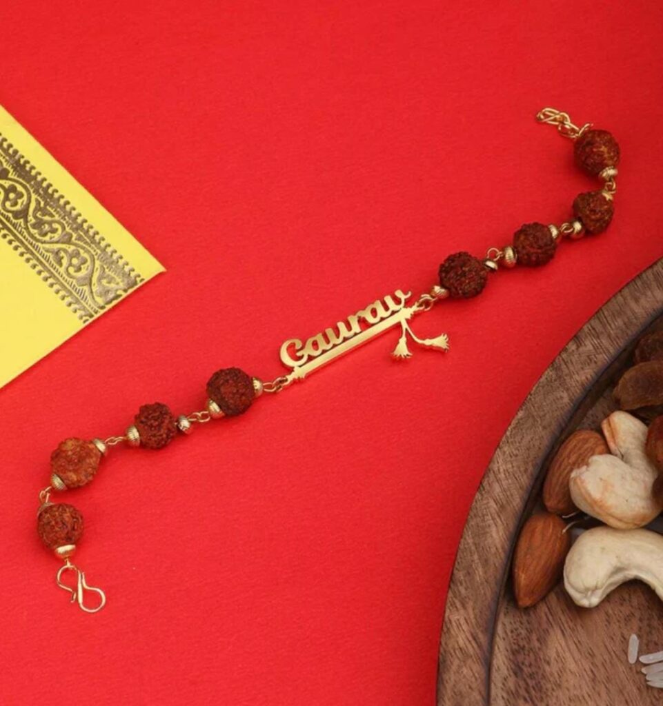 Customized Rudraksha name Rakhi bracelet with natural Rudraksha beads, gold-finish engraved name plate, and adjustable chain.