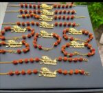 Premium Rudraksha bead Rakhi bracelet featuring a personalized gold name plate with peacock feather design for Raksha Bandhan.