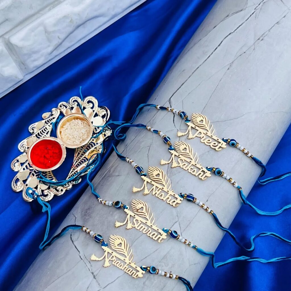 Custom Peacock Feather Name Rakhi with gold engraved name plate, evil eye beads, and premium blue silk thread for Raksha Bandhan.