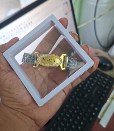 Custom premium name bracelet Rakhi with engraved gold name plate, stainless steel mesh strap, and magnetic clasp.