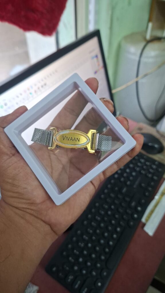 Custom premium name bracelet Rakhi with engraved gold name plate, stainless steel mesh strap, and magnetic clasp.