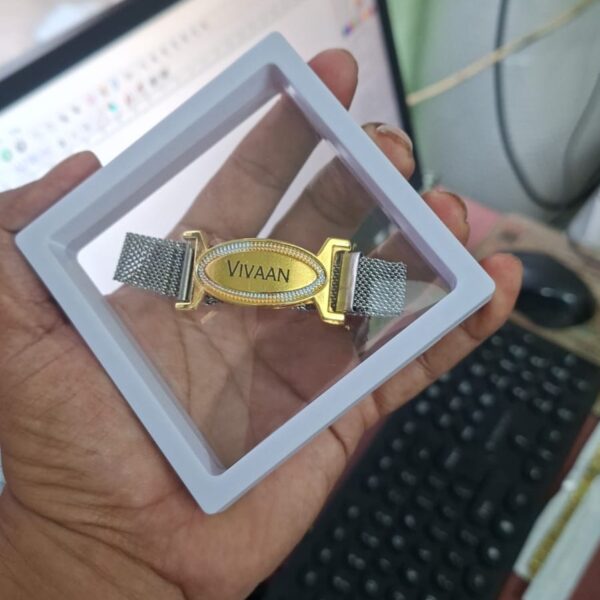 Custom premium name bracelet Rakhi with engraved gold name plate, stainless steel mesh strap, and magnetic clasp.