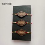 Custom engraved wooden name Rakhi featuring an elegant laser-cut pattern, premium pearl beads, and handcrafted festive red thread.