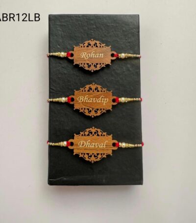 Personalized designer wooden name Rakhi with intricate laser-cut design, pearl bead accents, and traditional red thread for Raksha Bandhan.