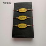 Personalized oval name plate Rakhi available in gold and silver finish with custom engraving, pearl beads, and traditional red thread.