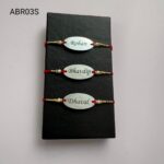 Custom engraved gold and silver oval name Rakhi with elegant pearl detailing for Raksha Bandhan.